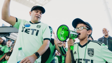 Eli and Dad cheering at Austin FC game