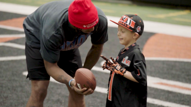 Ja'Marr Chase handing a football to wish kid Brixton