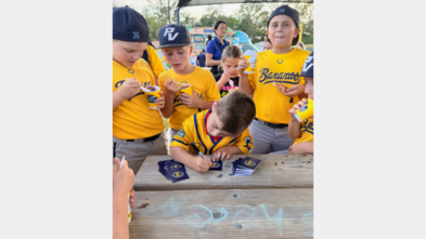 Dominic signing his baseball cards