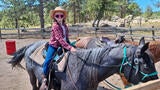 Wish kid Mary Alice riding a horse wearing a cowboy hat and sunglasses