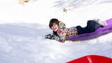Wish kid Nash sledding in the snow