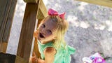 Wish kid Macie climbing a ladder to her new treehouse
