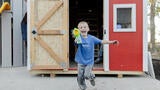 Wish kid David in front of his new playhouse