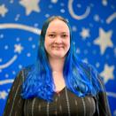 Kaula Schadle in front of a blue wall with star decals
