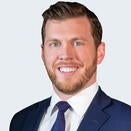 A man smiling with a suit and tie.