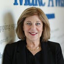 Jodi Stoken, Chief Development Officer, in front of Wish Wall