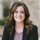 Elise in a black suit posing for a headshot