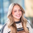 Woman smiling with long blond hair, striped sweater