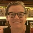 Rebecca in glasses and black shirt smiling for a photo