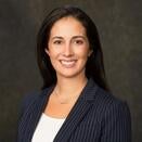 Elise in a black suit posing for a headshot