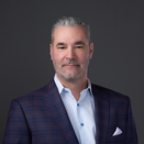 Andy Dunning smiling and wearing white and blue shirt and plaid sport coat