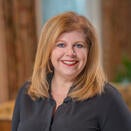 Woman with red hair wearing grey jacket 