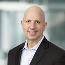 Marty Brimmage smiling and wearing a white shirt with black suir coat