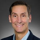 Maurizio Ghisoli smiling and wearing a blue shirt and suit jacket