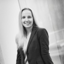 Black and white photo of Michelle Carroll smiling and wearing a shirt and blazer