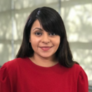 Tina Mahal smiling and wearing a red blouse