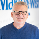 David Raber, Chief Administrative Officer, in front of Wish Wall