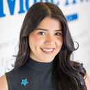 Julieta Montejano, Donor Relations Manager, in front of Wish Wall