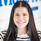 Taylor Loomis, Senior Director of Community Engagement, in front of Wish Wall