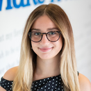 Alexis Heichman, Marketing Coordinator, in front of Wish Wall