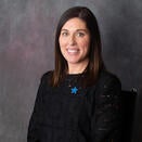 Head shot of Brekka in a black shirt and a star pin