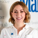 Jessica Haag, Senior Director of PR & Marketing, standing in front of Wish Wall