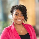Young black woman with pink jacket over black top