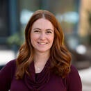 Woman with shoulder length red hair, burgundy top