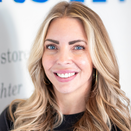 Janna Mortensen, Executive Assistant, standing in front of Wish Wall