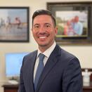 Justin Lowenfield smiling in grey suit