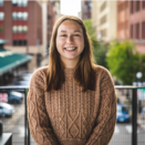 Headshot of Sarah in a brown sweater