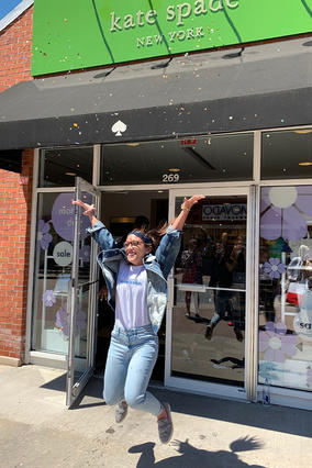 Alexis jumps for joy outside her favorite store. 