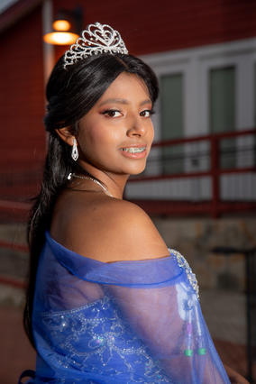 Karla in a tiara and royal blue dress poses for the camera