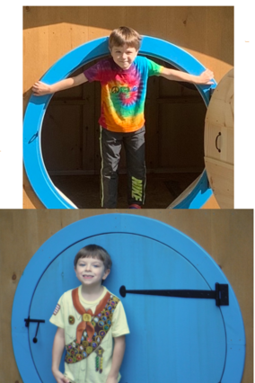 Wish child Drew standing proudly in the doorway of his Hobbit Hole.