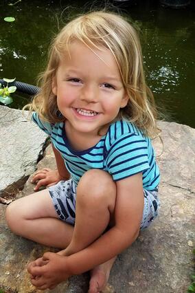 Michael sits on a rock near a river