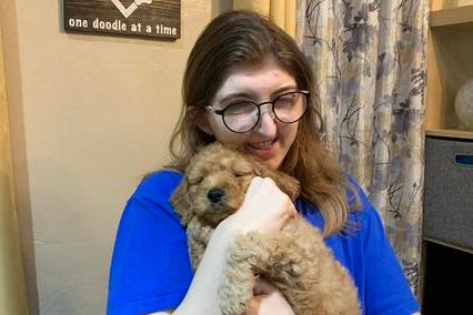 Wish kid Rebecca works with the puppies, helping with feeding, socialization, training and giving them lots of pets.