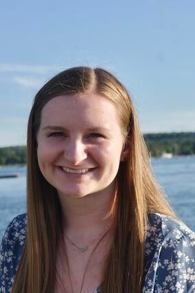 Intern Megan portrait photo daytime with water behind her