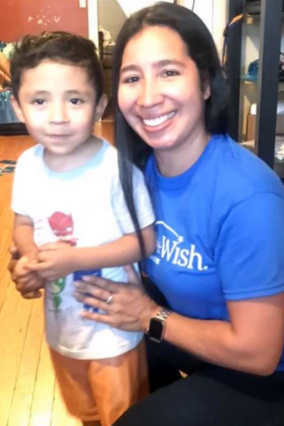 Volunteer Debbie smiling with wish child Jesus