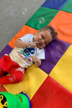 Khami smiles as bubbles are blown around him.