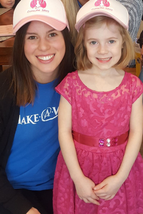 Volunteer Olivia smiles with wish child Clara