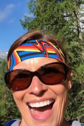 Laurie smiling wide with sunglasses and headband