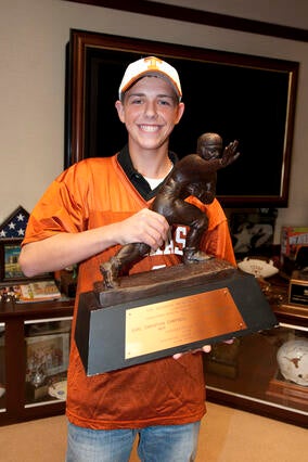 Wish Alumni Greg holding Mack Brown's Heisman Trophy