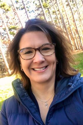 Teresa smiling with glasses and brown hair