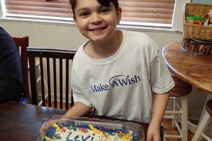 Wish kid Levi showing his wish day cake
