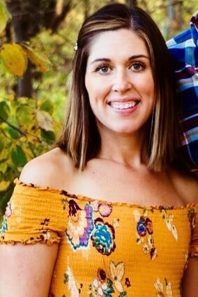 Brekka short brown hair in a yellow floral shirt smiling