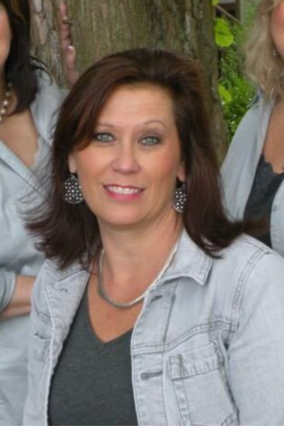 Nancy short brown hair and blue eyes smiling