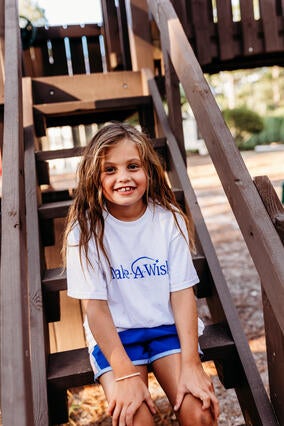 Caroline smiles on the steps of her playlet