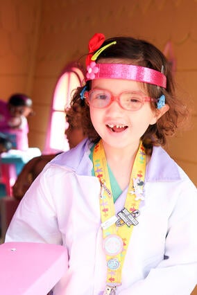 Wish kid Penny in her doctors coat