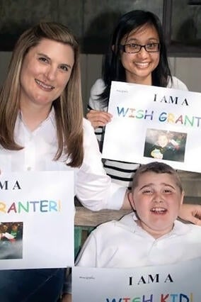 Volunteer wish granters Erin (left) and Vincis with wish kid Wyatt