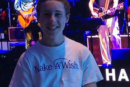 Zach posing in front of the stage at the concert